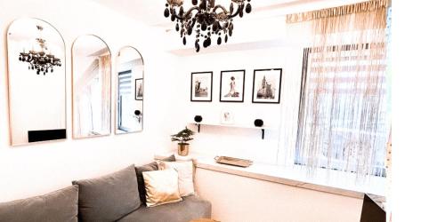 ein Wohnzimmer mit einem Sofa und einem Kronleuchter in der Unterkunft Apartament Kameralny15 in Danzig