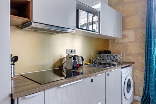 uma cozinha com um lavatório e um fogão forno superior em GuestReady - Stylish Haven in Downtown Bordeaux em Bordeaux