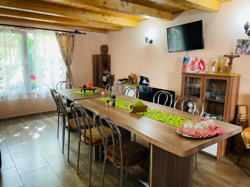 a dining room with a large wooden table and chairs at Balla House in Tărcaia