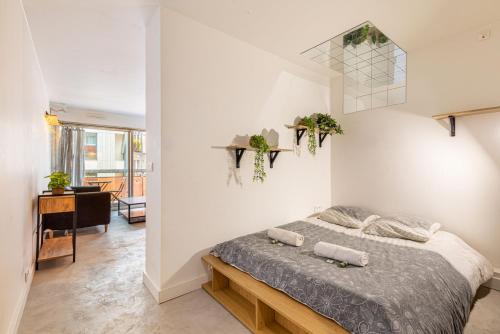 1 dormitorio con 1 cama en una habitación blanca en GuestReady - Marvellous escape near Gare du Nord en París