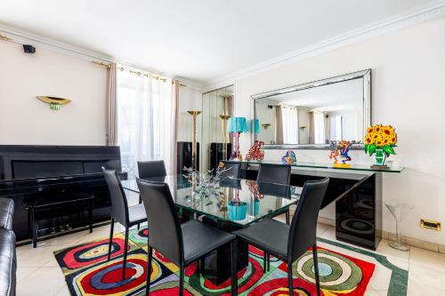 une salle à manger avec une table en verre et un miroir dans l'établissement GuestReady - A Slice of Parisian Paradise, à Paris