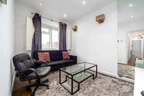 un soggiorno con divano nero e tavolo in vetro di GuestReady - Petite Perfection near Battersea Park a Londra
