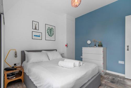 GuestReady - Bright flat in Westminster في لندن: غرفة نوم بسرير ابيض وجدار ازرق