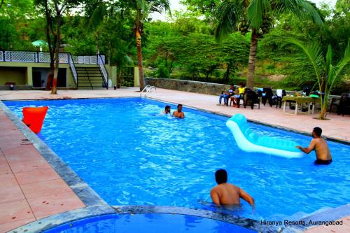 un grupo de personas jugando en una piscina en Hiranya Resorts, en Daulatābād