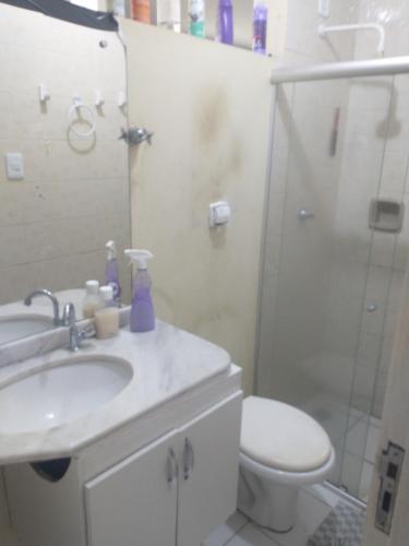 een badkamer met een wastafel, een toilet en een douche bij Hospedagem jatiuca in Maceió