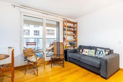 un salon avec un canapé, une table et des chaises dans l'établissement GuestReady - Appartement Chic avec Balcon, à Saint-Denis