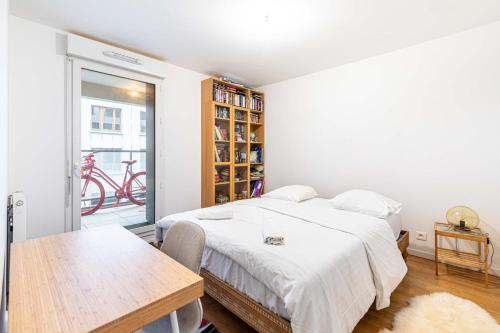 une chambre avec un lit, une table et une fenêtre dans l'établissement GuestReady - Appartement Chic avec Balcon, à Saint-Denis