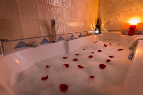 a bath tub filled with red rose petals at Romantic house for 2 or 4 people with jacuzzi in El Reul Alto