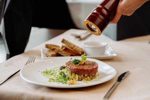 a person is serving a plate of food on a table at Hotel Wileński in Olsztyn