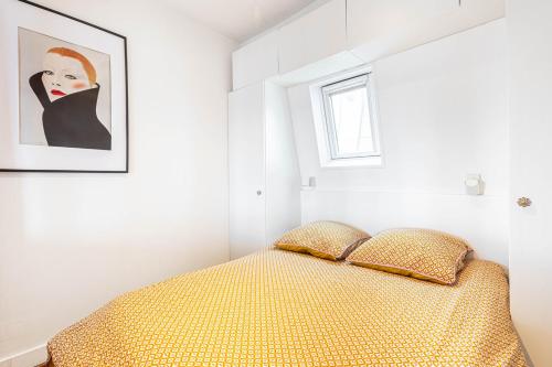 une chambre avec un lit et un tableau au mur dans l'établissement GuestReady - Séjour Confortable à Paris, à Paris