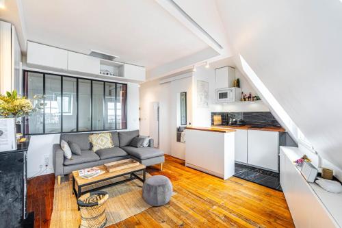 un salon avec un canapé et une cuisine dans l'établissement GuestReady - Séjour Confortable à Paris, à Paris