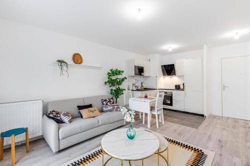 un salon avec un canapé et une table dans l'établissement GuestReady - Bel Apt. à Asnières-sur-Seine, à Asnières-sur-Seine