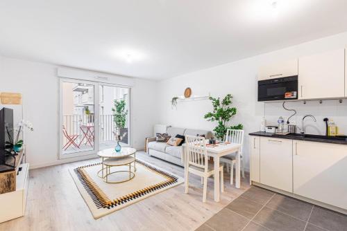une cuisine et un salon avec un canapé et une table dans l'établissement GuestReady - Bel Apt. à Asnières-sur-Seine, à Asnières-sur-Seine