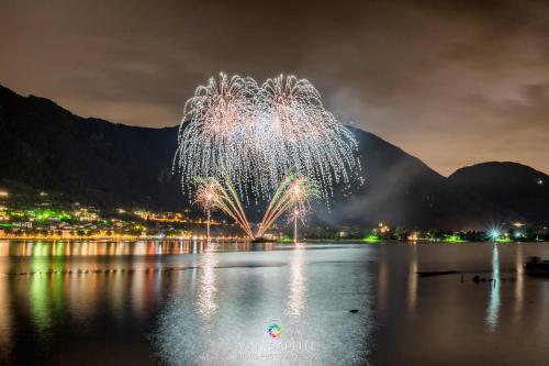 a firework display over the water with a mountain in the background at Due Pini Apartment - Ponte Caffaro Lake Idro in Ponte Caffaro