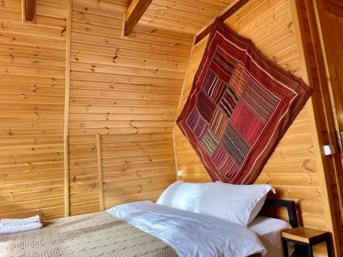 a bedroom with a bed in a wooden room at Kazbegi Kuro Cottages in Stepantsminda