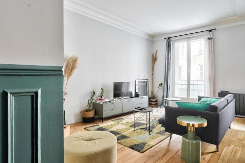 un salon avec un canapé et une télévision dans l'établissement GuestReady - Gateway to Parisian Delight, à Paris