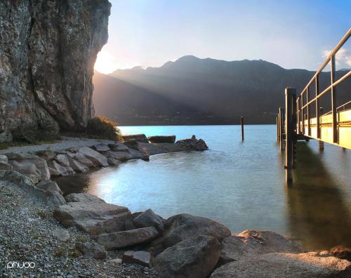 a body of water with a bridge in front of a mountain at Due Pini Apartment - Ponte Caffaro Lake Idro in Ponte Caffaro