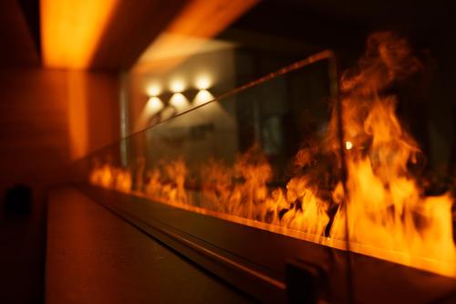 a fire is burning in a room with flames at RESIDENZ AM BERG in Hartmannsdorf