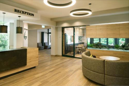 an office lobby with a couch and a fishtank at RESIDENZ AM BERG in Hartmannsdorf