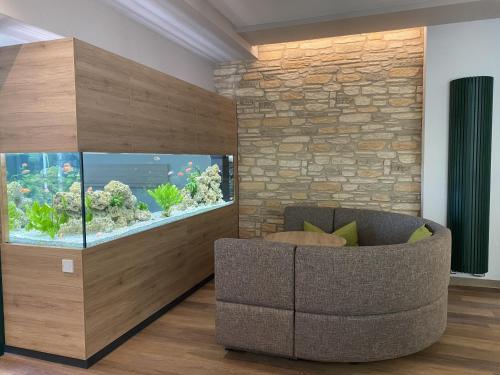 a living room with a fish tank and a couch at RESIDENZ AM BERG in Hartmannsdorf