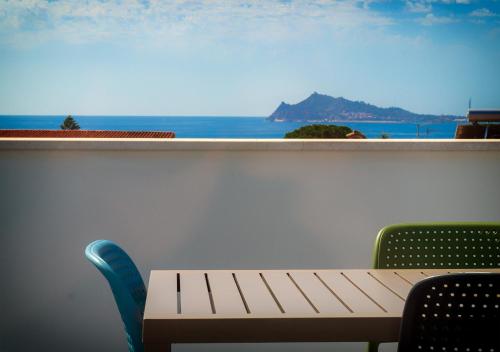 a table and chairs with a view of the ocean at Resort Beach Cala Goloritzè in Santa Maria Navarrese