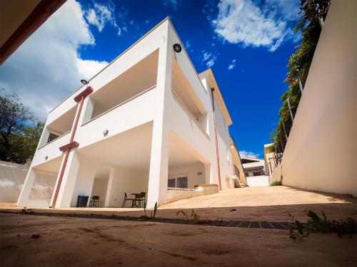 una casa blanca con muchas ventanas en Resort Beach Cala Goloritzè, en Santa Maria Navarrese