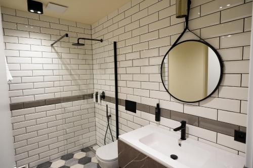 a white bathroom with a sink and a mirror at Seven Town House Boutique Hotel in Locarno