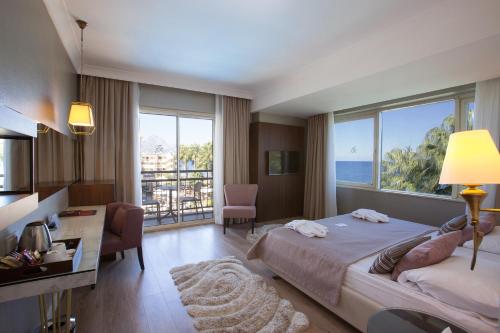 a bedroom with a large bed with a view of the ocean at Fame Residence Kemer & Spa in Kemer