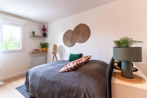 a bedroom with a bed and a lamp and a window at Cocon Coloré - Studio pour 2 30min de Paris in Chevilly-Larue