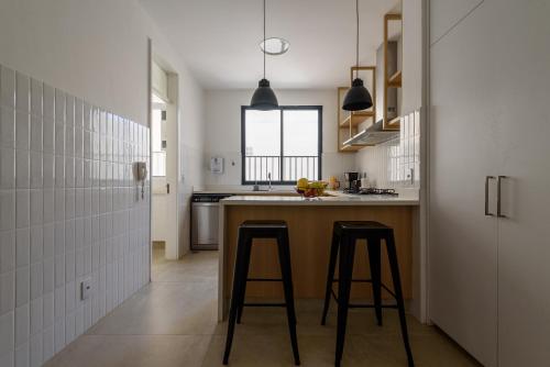 una cocina con 2 taburetes en una barra de cocina en Apartamento entre Copacabana e Ipanema en Río de Janeiro