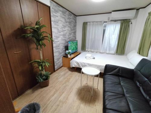 a small room with a bed and a couch at Nishi-shinjuku-ZYZ SJ0237 in Tokyo