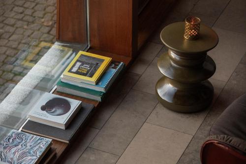 a glass table with books on it with a stack of books at Avalon Hotel in Gothenburg