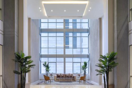 a large window in a lobby with a couch and chairs at Hotel 21 Makkah in Makkah