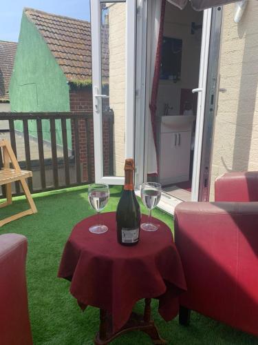 a bottle of wine sitting on a table with two glasses at All Seasons Guest House in Great Yarmouth