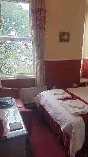 a hotel room with two beds and a window at All Seasons Guest House in Great Yarmouth