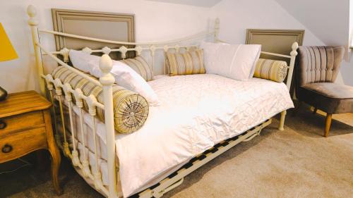 a bedroom with a white bed with a wooden frame at The Bat and Ball in Canterbury