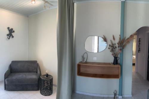 ein Wohnzimmer mit einem Stuhl und einem Spiegel in der Unterkunft LefkasLoft in Lefkada Town