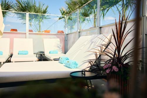 a bed on a balcony with plants and palm trees at Avalon Hotel in Gothenburg