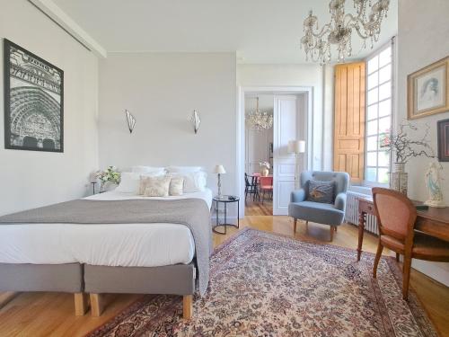 a bedroom with a bed and a desk and a chair at LA MAISON CANONIALE luxe et charme au coeur de Tours in Tours