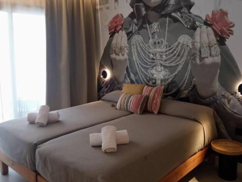 Dos camas en un dormitorio con toallas. en Apartamentos Orvay, en San Antonio