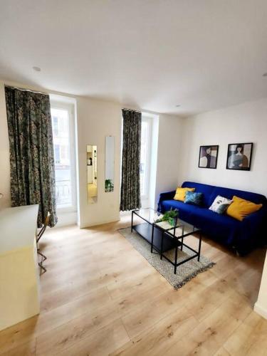 un salon avec un canapé bleu et une table dans l'établissement Bonito y Ambientado 10 AA1, à Paris