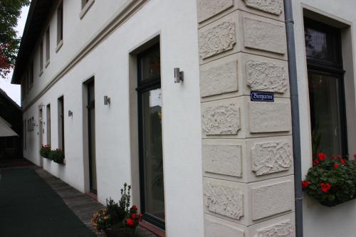 a white building with flowers on the side of it at Hotel Knipper in Lastrup