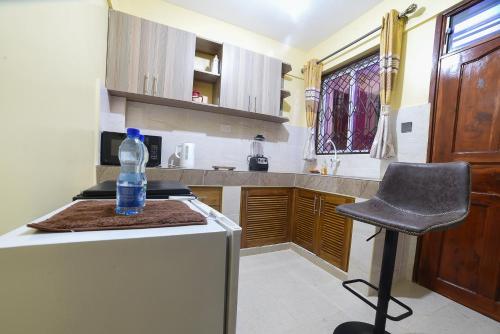 - une bouteille d'eau assise sur un comptoir dans la cuisine dans l'établissement MAXIMILIAN HOMES, à Kilifi