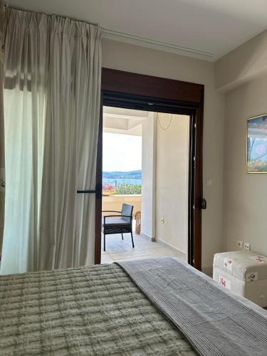 a bedroom with a bed and a table and a chair at Navy View in Paleo Tsifliki