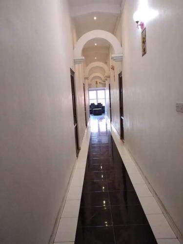 a hallway of a building with white walls and black floors at Anand Villa Guest house in Plaine Magnien