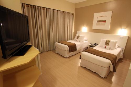 Un pat sau paturi într-o cameră la Hotel Curi Executive