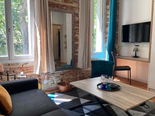 un salon avec un canapé et une table dans l'établissement Luxine 2 - Appartement 4 pers - Proximité Gare Matabiau, à Toulouse