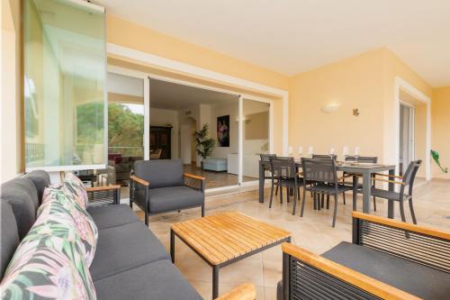 ein Wohnzimmer mit einem Sofa, einem Tisch und Stühlen in der Unterkunft 2 bedroom apartment next to the beach in Elviria, Marbella in Marbella