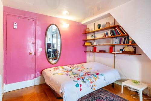 - une chambre rose avec un lit et un miroir dans l'établissement GuestReady - Parisian Bliss near the Louvre, à Paris