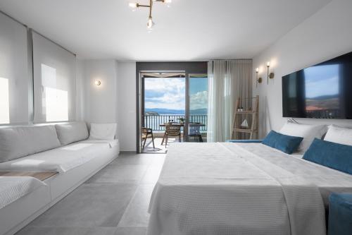 ネア・ローダにあるBlue Whisper Luxury Living Suitesの白いベッドルーム(大型ベッド1台、ソファ付)